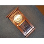 A wood cased, bevelled glazed wall clock, Arabic numerals to the dial, with key and pendulum,