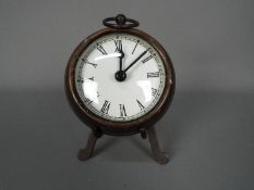 A small, antique style desk clock in the