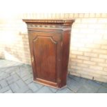 An antique hanging corner cupboard with