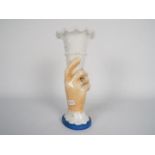 A late 19th or early 20th century glass vase in the form of a hand holding aloft a cornucopia,