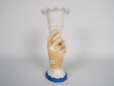A late 19th or early 20th century glass vase in the form of a hand holding aloft a cornucopia,