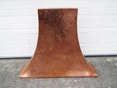 A copper fire hood, planished and riveted, approximately 102 cm x 125 cm x 20 cm.