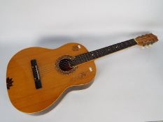 An acoustic guitar by Kremona.