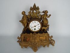 A figural mantel clock, Roman numerals to a 3" enamel dial.