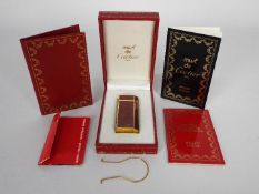 A Must de Cartier Briquet cigarette lighter contained in original box with paperwork.