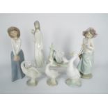 A collection of seven Spanish porcelain figurines to include Lladro, Nao and similar,