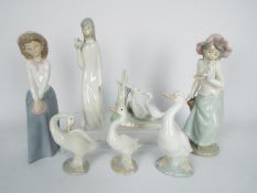 A collection of seven Spanish porcelain figurines to include Lladro, Nao and similar,