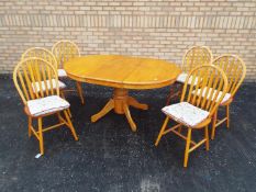 An extending kitchen table and six chairs,