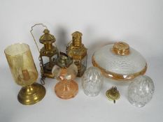 A collection of brass oil lanterns, glass shades and similar.