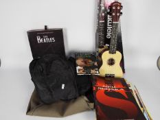 A quantity of vintage sheet music, two guitar carry cases and a boxed ukulele.