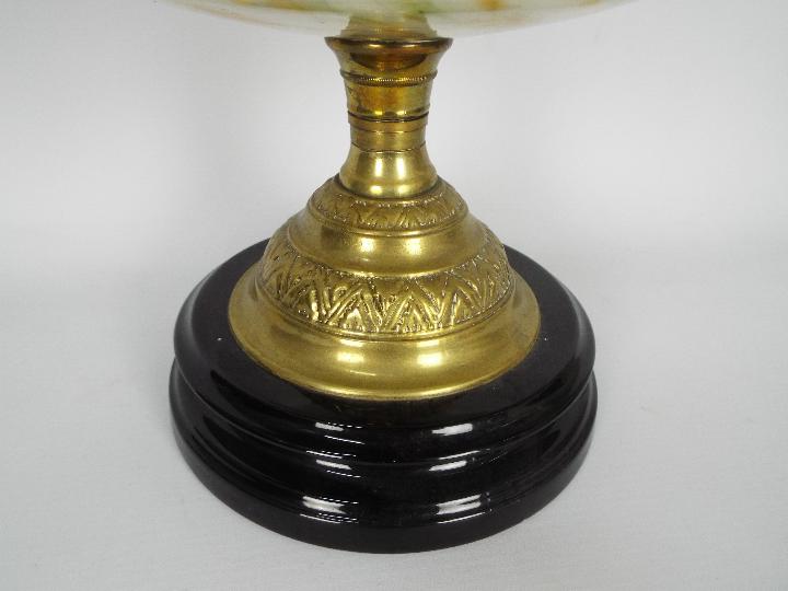 An oil lamp with black ceramic base and brass support below a mottled glass reservoir and floral - Image 4 of 4