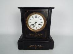 A French black slate mantel clock with incised gilt highlights, Roman numerals to a 4" enamel dial,