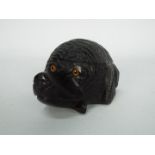 A black forest carved wood inkwell in the form of a dog's head with glass eyes and blue ceramic