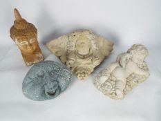 A collection of reconstituted stone garden ornaments to include wall pocket, recumbent putto,