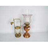 A copper and brass oil lamp with glass shade,