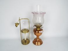 A copper and brass oil lamp with glass shade,