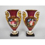 A pair of Vienna style porcelain, twin handled urns each decorated with floral panels,