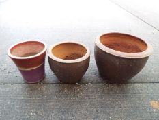 Three garden planters of cylindrical form, largest approximately 39 cm x 51 cm.