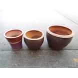 Three garden planters of cylindrical form, largest approximately 39 cm x 51 cm.