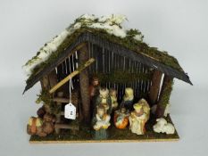 A Christmas Nativity diorama with ceramic figures,