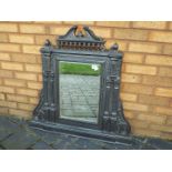 A cast iron framed overmantel mirror of architectural form with bevelled pane,