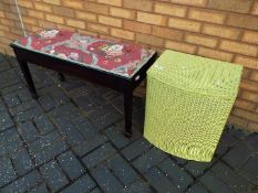 A double piano stool with lift up, upholstered seat on spade foot supports,