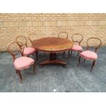 A mahogany, circular, tilt top table and six balloon back dining chairs,