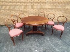 A mahogany, circular, tilt top table and six balloon back dining chairs,