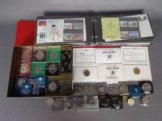 Philately - A binder containing first day covers and mint stamps and a small quantity of coins,