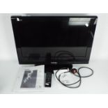 A Toshiba 26" flatscreen television, model 26A615DB, with remote and instructions.
