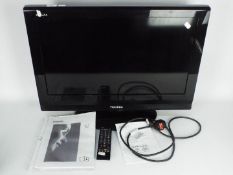 A Toshiba 26" flatscreen television, model 26A615DB, with remote and instructions.