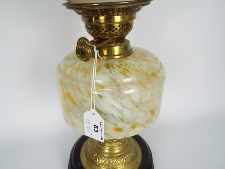 An oil lamp with black ceramic base and brass support below a mottled glass reservoir and floral - Image 3 of 4