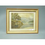 A late 19th or early 20th century watercolour landscape depicting a lakeside scene,