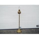 A floor standing, telescopic, brass oil lamp, approximately 144 cm (h) when at lowest setting.