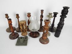 A collection of candlesticks / chambersticks, turned and carved wood examples, slate and other.