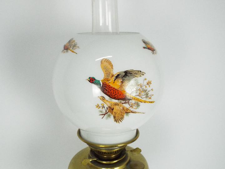 A brass oil lamp on circular base with four column supports, the shade decorated with game birds, - Image 2 of 11