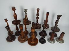 A good collection of turned wooden candlesticks including barley twist stem pair and similar,