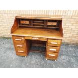 A 20th century six drawer writing bureau, the tambour top opening to reveal a fitted interior,