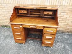 A 20th century six drawer writing bureau, the tambour top opening to reveal a fitted interior,