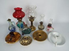 A collection of oil lamps, candle stands, chambersticks, largest approximately 28 cm (h).