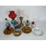 A collection of oil lamps, candle stands, chambersticks, largest approximately 28 cm (h).