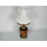 A converted oil lamp, brass with ceramic reservoir and milk glass shade, approximately 48 cm (h).