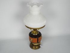 A converted oil lamp, brass with ceramic reservoir and milk glass shade, approximately 48 cm (h).