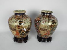 A pair of Japanese vases of ovoid form decorated with panels of a well dressed lady in a garden