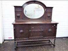 A mirror back, oak sideboard with carved detailing, approximately 173 cm x 153 cm x 55 cm.