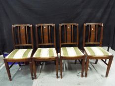 Four dining chairs with upholstered seats.