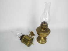 Two brass oil lamps, one with wall mount, largest approximately 40 cm (h) including chimney.