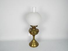 A brass oil lamp with fluted column supp