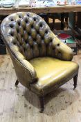 Light brown leather deep buttoned back tub chair raised on turned mahogany legs.