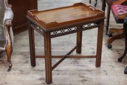 Mahogany tray top table with fretwork freeze, raised on four reeded legs to cross stretcher.